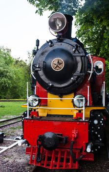 Steam locomotive with the smoke blowing off out of the smokestack.