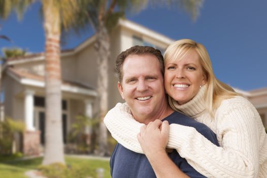 Happy Couple Hugging in Front of Beautiful House.