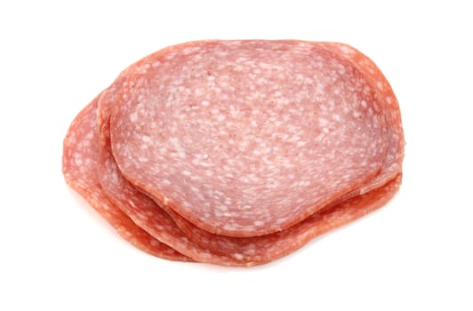 Slices of German salami sausage in a pile, isolated on a white background