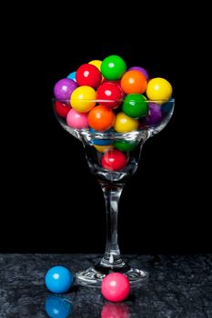 A cocktail glass filled with gum balls.