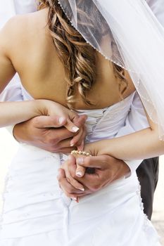 Wedding couple holding hands and hugging.