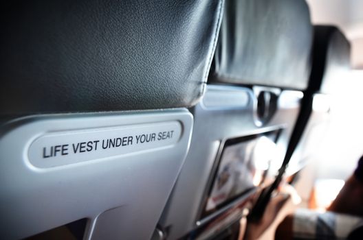 airplane seat with life vest under your seat text