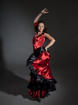 Young woman dancing flamenco, studio shot, gray background