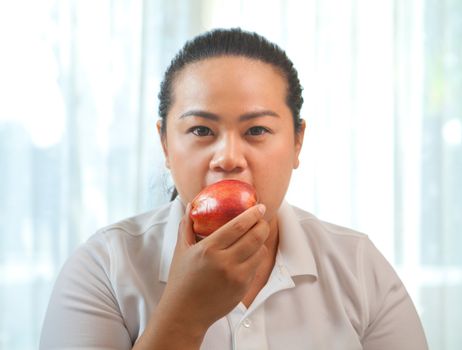 Fat asian woman with apple on white