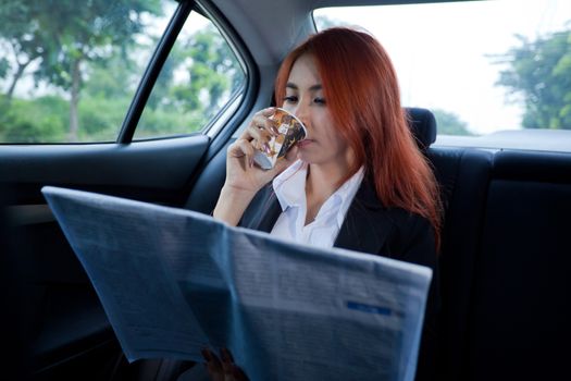 Business asian woman drinking coffee while driving