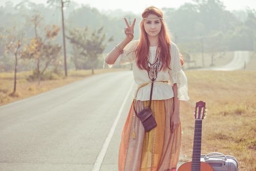 Hippie girl with peace signs in golden field