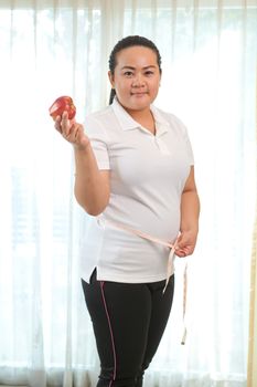 Fat asian woman with apple on white