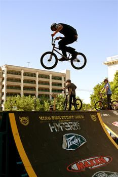 Athens, GA, USA - April 26, 2014:  A young man practices his park jumping tricks before the start of the BMX Trans Jam competition on the streets of downtown Athens.
