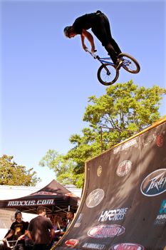 Athens, GA, USA - April 26, 2014:  A man practices his park jumping tricks before the start of the BMX Trans Jam competition on the streets of downtown Athens.