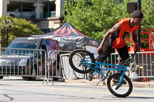 Athens, GA, USA - April 26, 2014:  A young male practices his flatland tricks before the start of the BMX Trans Jam competition on the streets of downtown Athens.