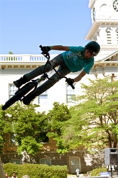 Athens, GA, USA - April 26, 2014:  A teenage boy practices his park jumping tricks before the start of the BMX Trans Jam competition on the streets of downtown Athens.