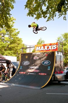 Athens, GA, USA - April 26, 2014:  A young man practices his ramp jumps before the start of the BMX Trans Jam competition on the streets of downtown Athens.