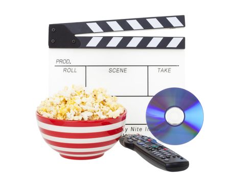 Movie night theme.  A bowl of fresh popcorn, with clapper board, movie and television remote.  Shot on white background.