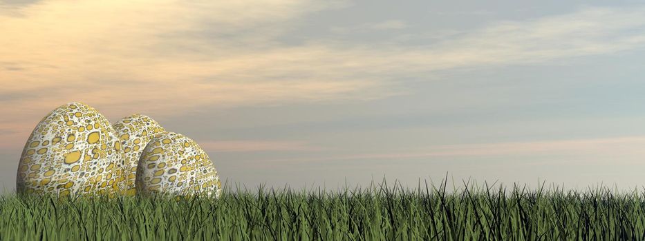 Three colorful easter eggs in the grass by sunset