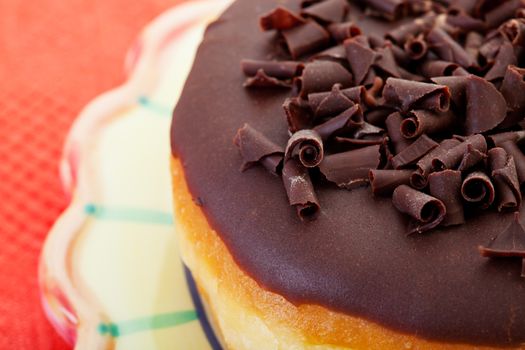 A chocolate, cream filled, bismark doughnut garnished with delicate curls of chocolate.
