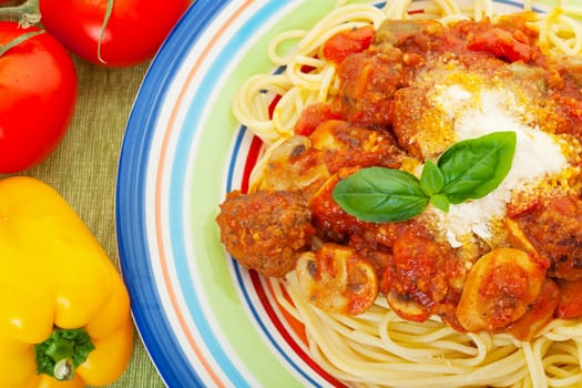 Plate of spaghetti with meatballs in a rich, tomato sauce made with fresh mushrooms, peppers, and tomato.