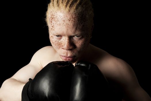 An albino African-American boxer on black background.