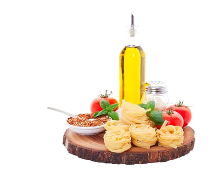 Tagliatelle Nests, olive, oil, tomatoes, parmesan cheese, garlic, crushed red pepper, and fresh basil on a rustic wooden cutting board.  Shot on white background.