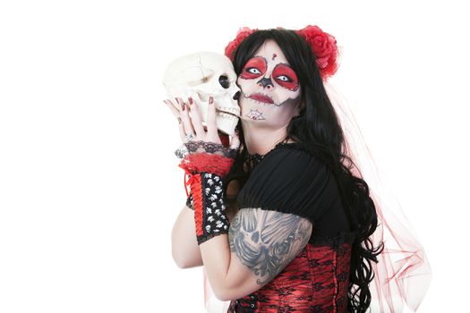 Day of The Dead.  A woman dressed as a sugar skull holding close, the skull of a departed love one.