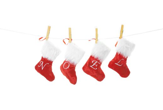 Red velvet Christmas stockings hung on a clothesline, spell noel.  Shot on white background.