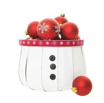 A snowman inspired basket bulging with a multitude of red Christmas balls on white background.