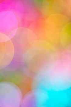 A soft, dreamy bokeh background in a blend of fuchsia, pink, blue, yellow, green, & mauve.