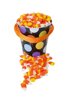A brightly colored bucket full of candy corn.  Shot on white background.