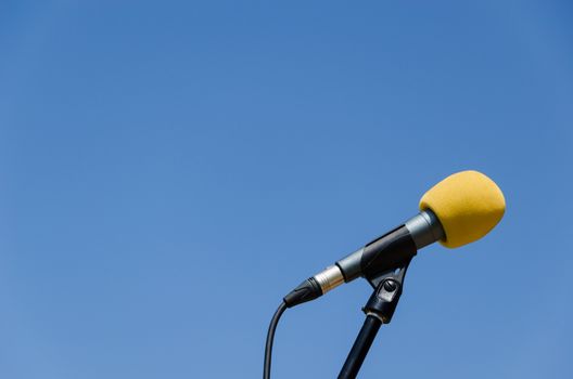yellow microphone on blue sky bakcground