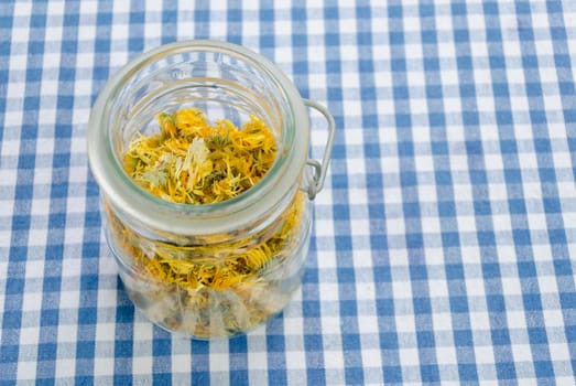 jar of dried organic herbal healing calendula on table