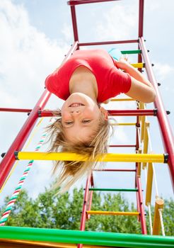 Little girl having fun playing on monkey bars