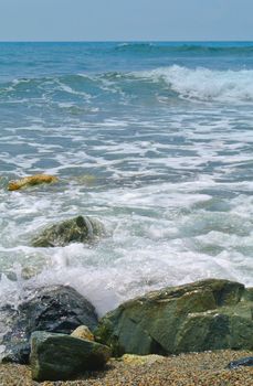 Sea coming to beach, with big rocks