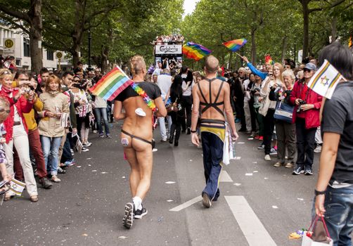 BERLIN, GERMANY - JUNE 21, 2014:Christopher Street Day.Crowd of people participate in the parade celebrates gays, lesbians, bisexuals and transgenders.Prominent in the image an unidentified participants and crowd of onlookers.