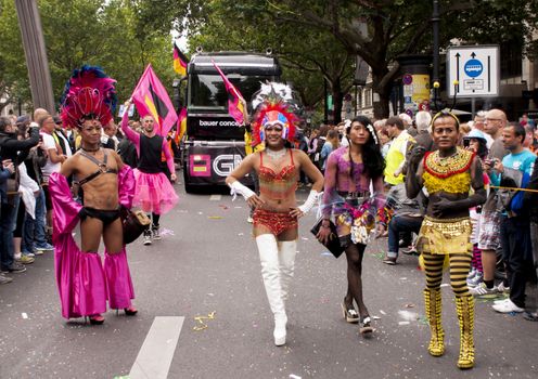 BERLIN, GERMANY - JUNE 21, 2014:Christopher Street Day.Crowd of people participate in the parade celebrates gays, lesbians, bisexuals and transgenders.Prominent in the image an unidentified elaborately dressed participants and crowd of onlookers.