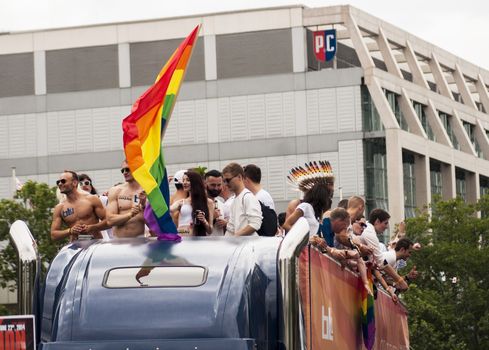 BERLIN, GERMANY - JUNE 21, 2014:Christopher Street Day. Crowd of people participate in the parade celebrates gays, lesbians, bisexuals and transgenders in Berlin. Group unidentified participants during Gay pride parade.In the background KaDeWe - Europe's Biggest Department Store.