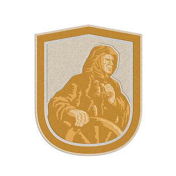 Metallic styled illustration of a fisherman sea captain with binoculars at the wheel helm set inside shield crest done in retro style on isolated white background. 