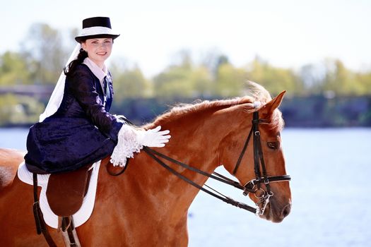 Lady on a  horse. The lady on riding walk. Portrait of the horsewoman. The woman astride a horse. The aristocrat on riding walk.