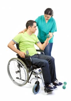 Physical therapist works with patient in lifting hands weights. Young adult in wheelchair.