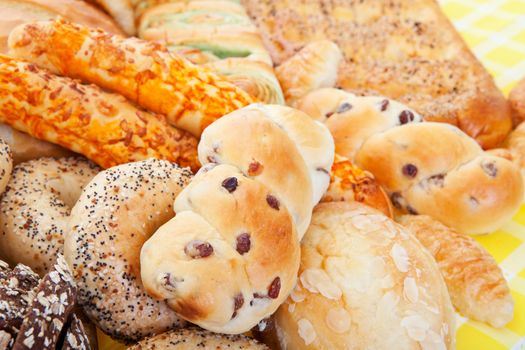 A group of international breads, including Almond Bun, Buko Pandan Loaf,  Italian Cheese Sticks, & Pumpernickel. 