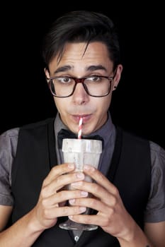 A geeky, nerd guy sucking chocolate milkshake through a straw.