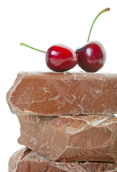 Fresh, deep red cherries on top of thick chunks of milk chocolate.  Shot on white background.