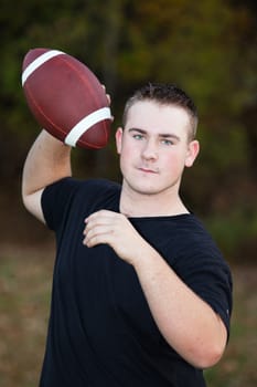 Teenager throwing a football around in the park.