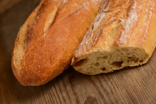 French crusty bread, isolated on a wooden plank background