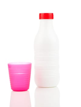 Milk bottle and plastic beaker isolated on white background