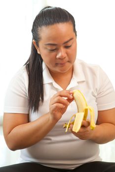 Fat asian woman with banana on white