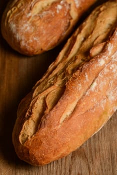 French crusty bread, isolated on a wooden plank background