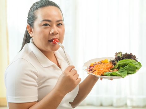 Asian fat woman eating salad on white