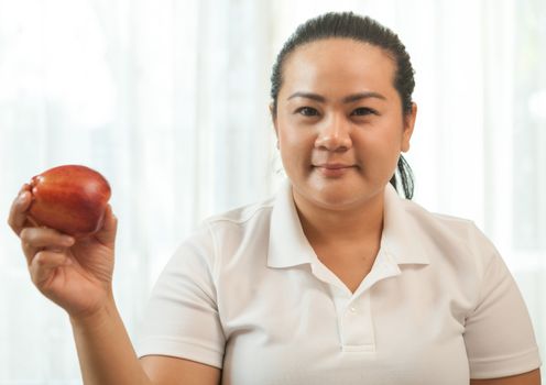 Fat asian woman with apple on white