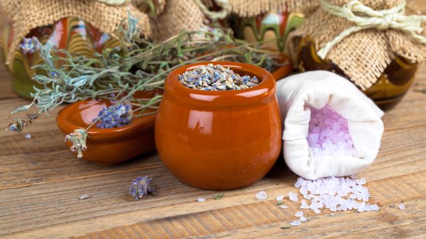 dry lavender flowers with bath salt, on wooden background.