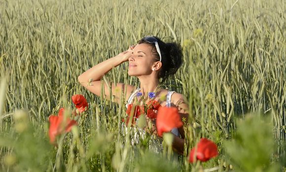 smiling young  woman picking bouquet in cornfield