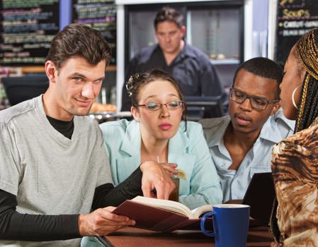 Clever male with students in coffee house